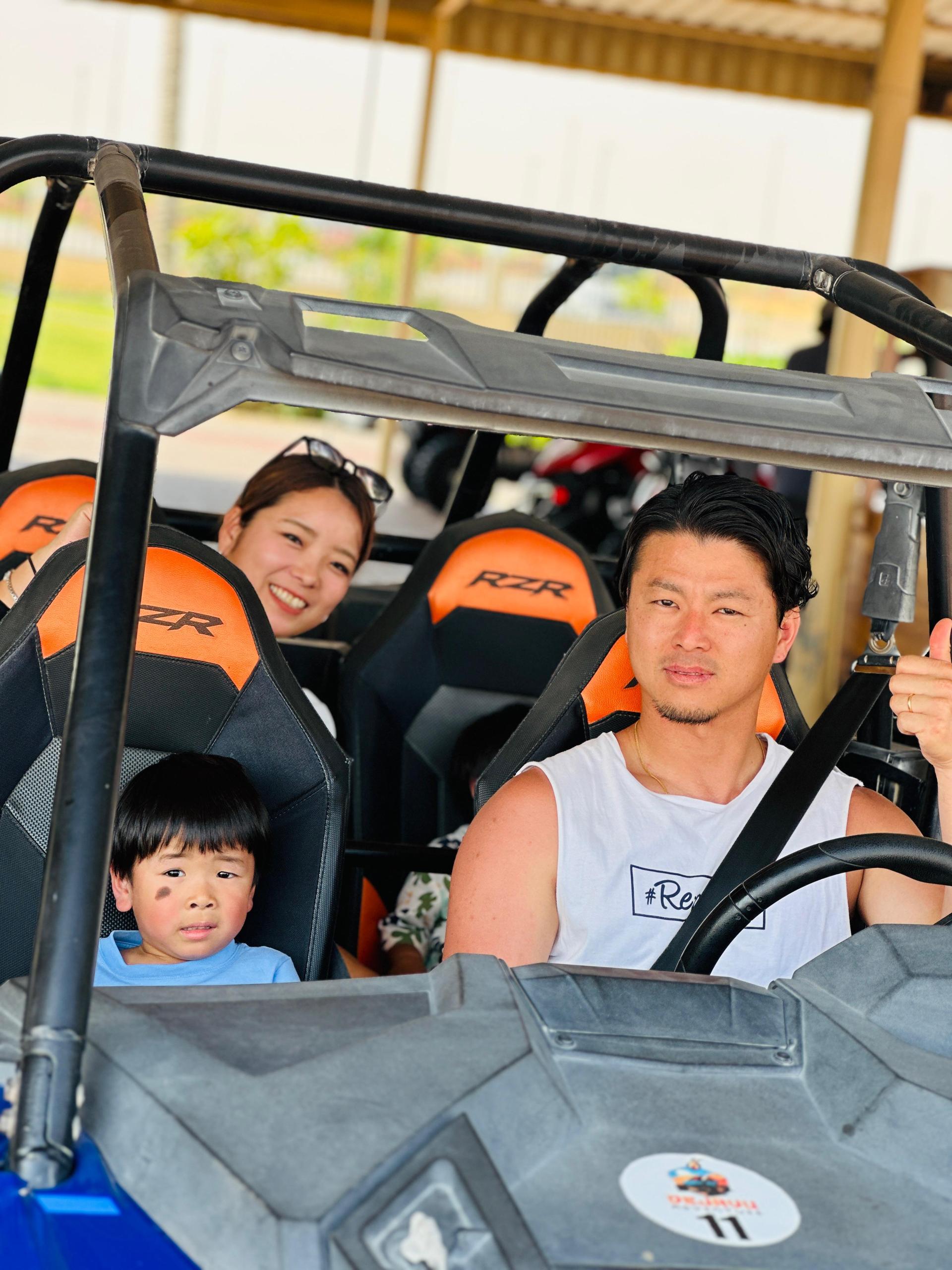 Group posing with dune buggy vehicle before desert safari ride Dubai