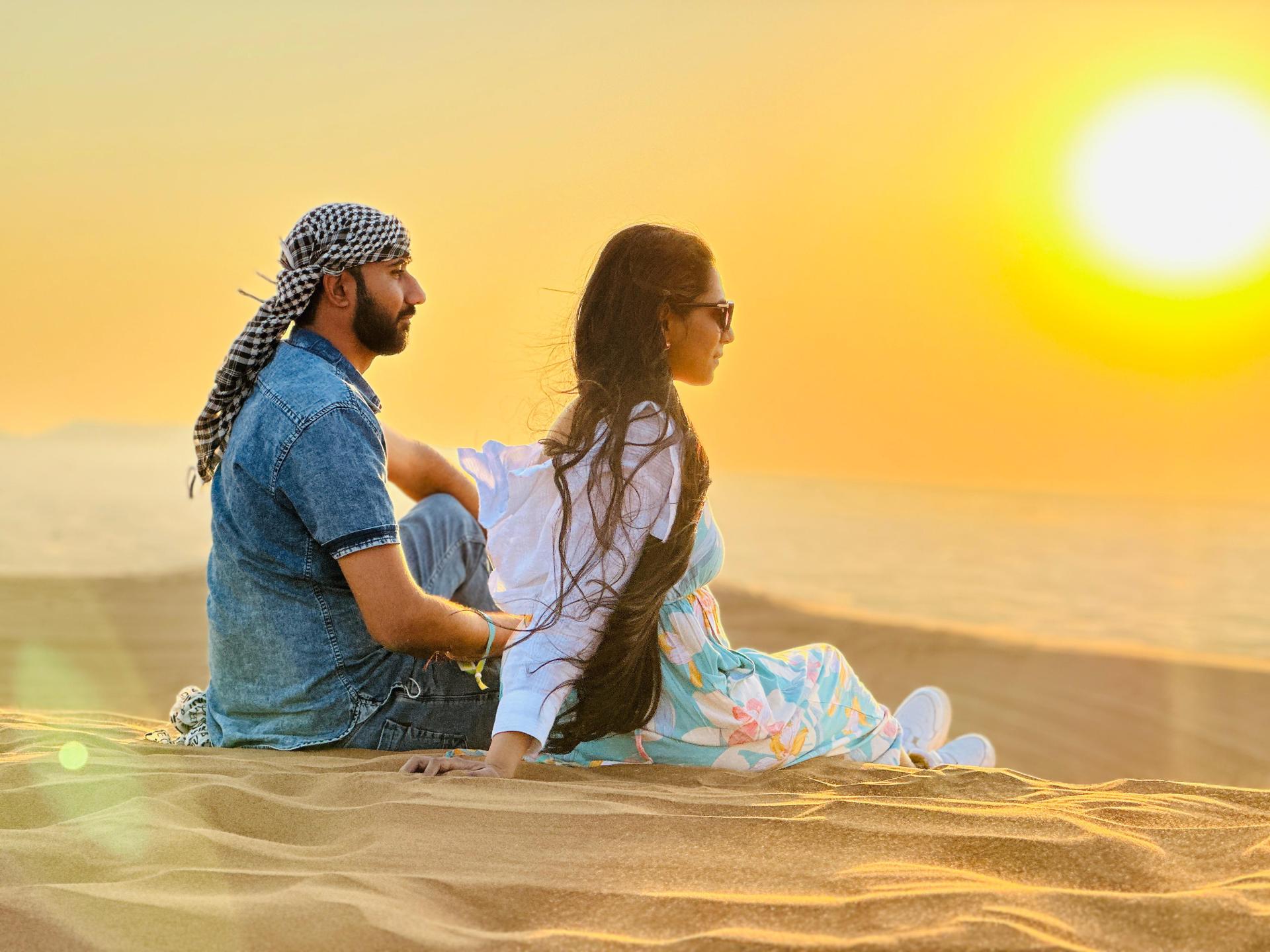Friends walking on sand dunes during evening desert safari in Dubai