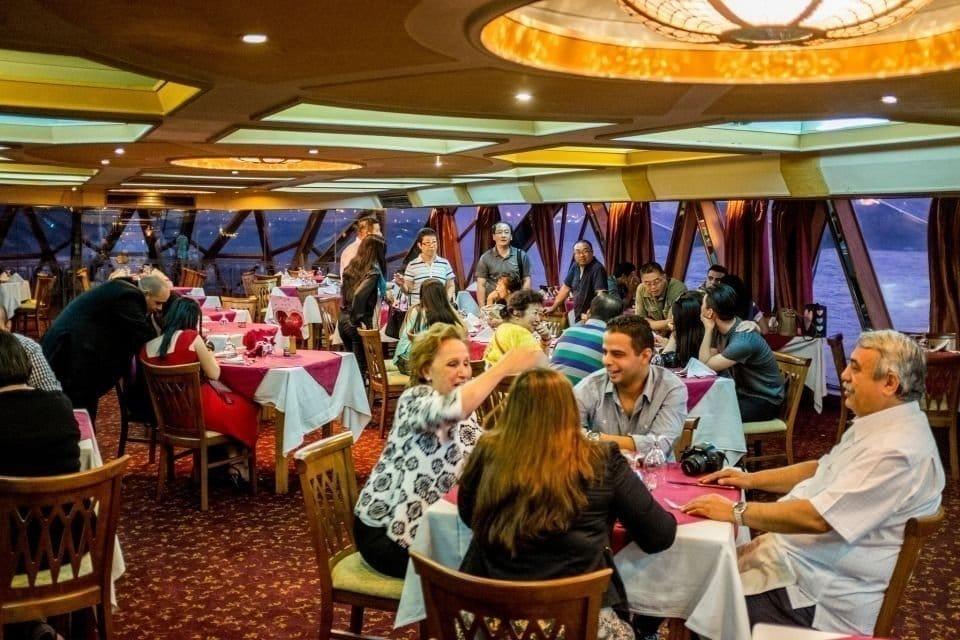 Diners at tables inside decorated Al Mansour dhow cruise Dubai