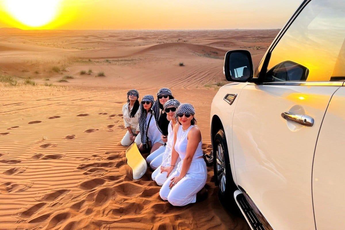 Family having fun on sand dunes during Dubai desert safari experience