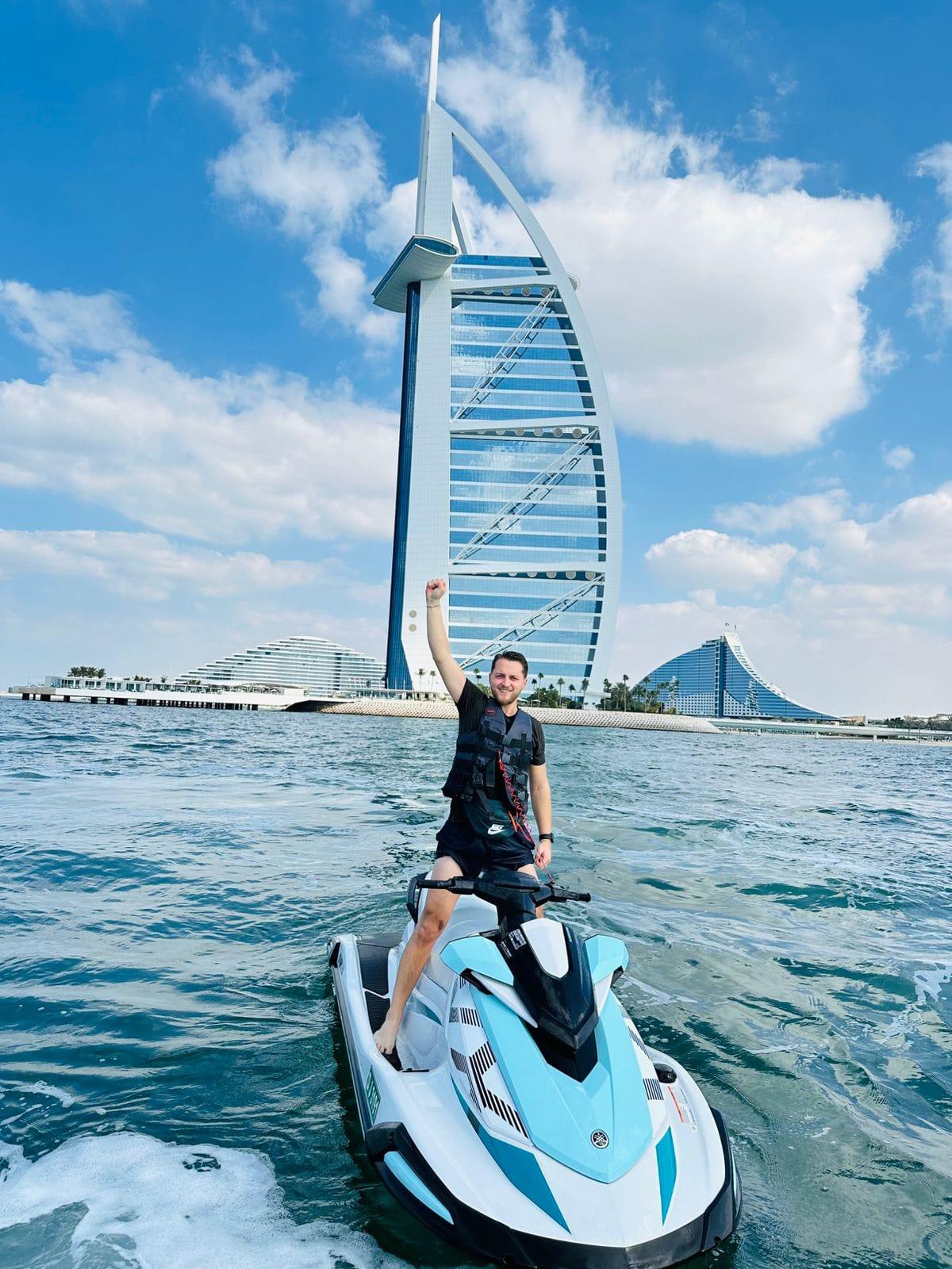 Jetski riders on open water with Dubai Marina skyline behind