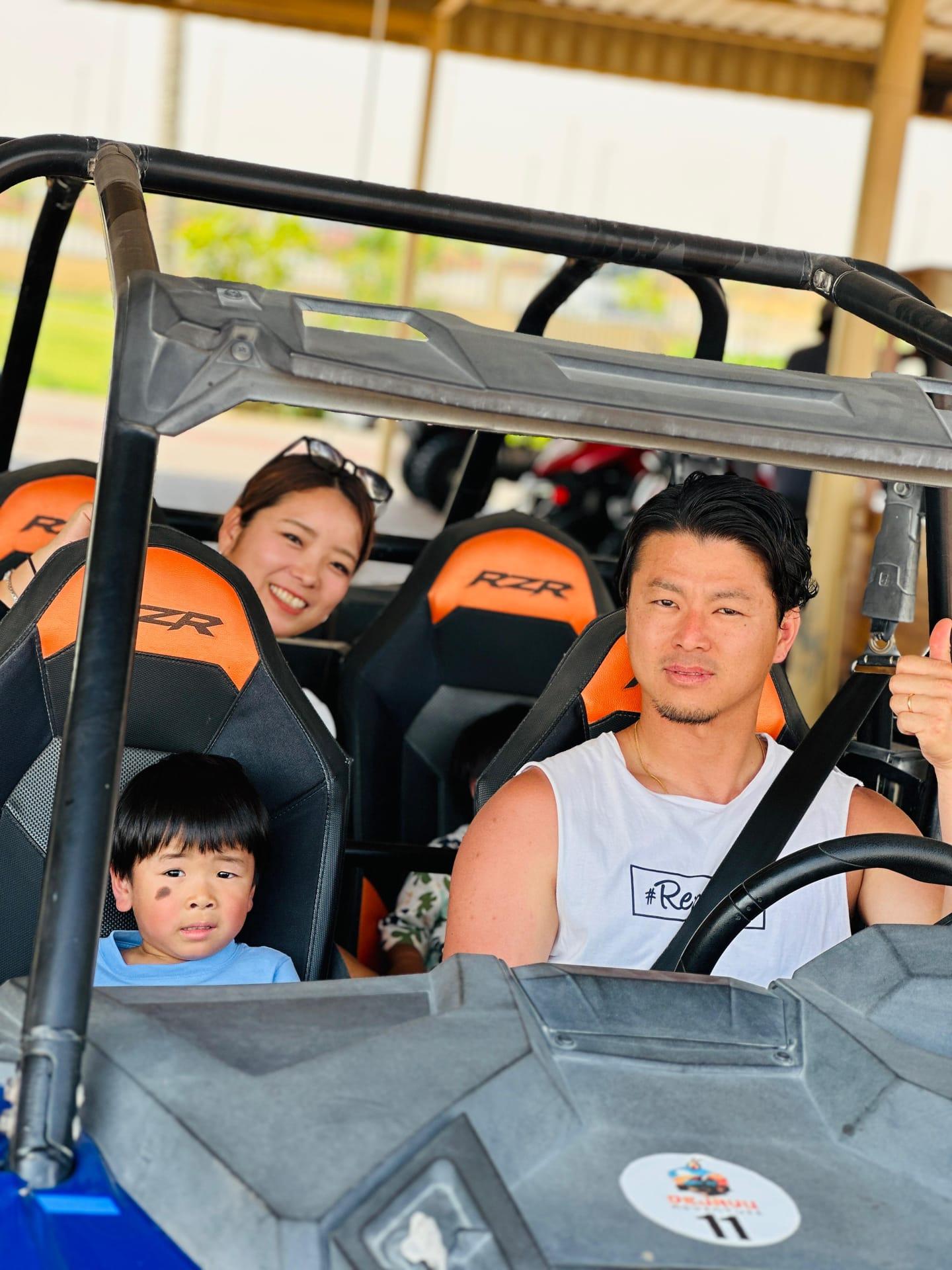Group posing with dune buggy vehicle before desert safari ride Dubai