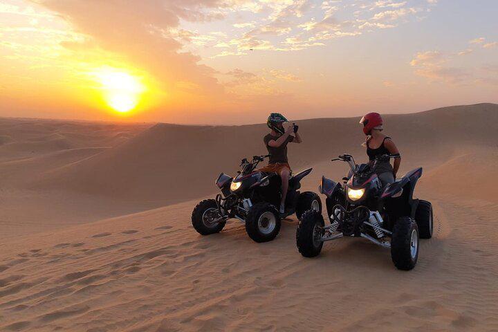 ATV quad bike parked on sand dunes at golden hour Dubai desert