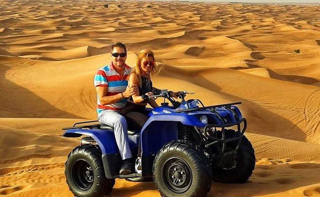 Group of quad bikes racing across Lahbab Red Dunes in Dubai