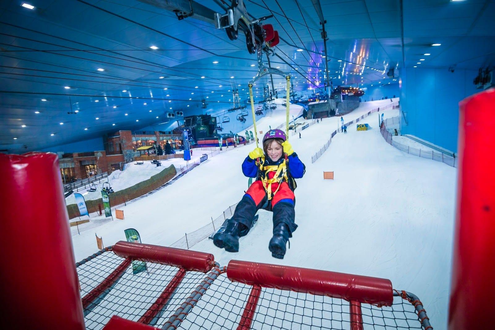 Children sledding on snow at Snow Classic indoor park Dubai